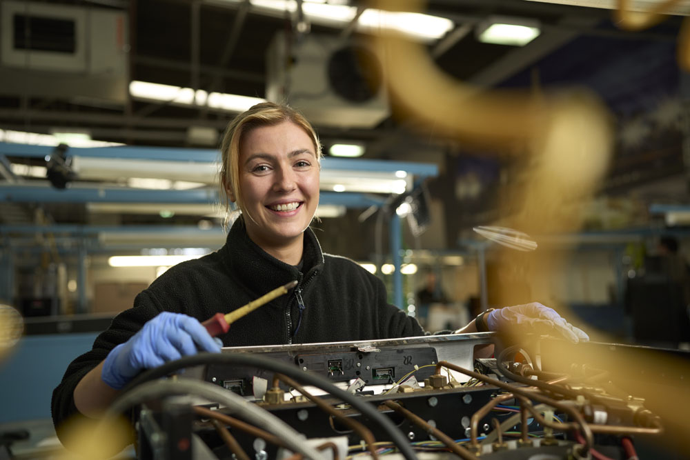 Young female engineer fixing a coffee machine