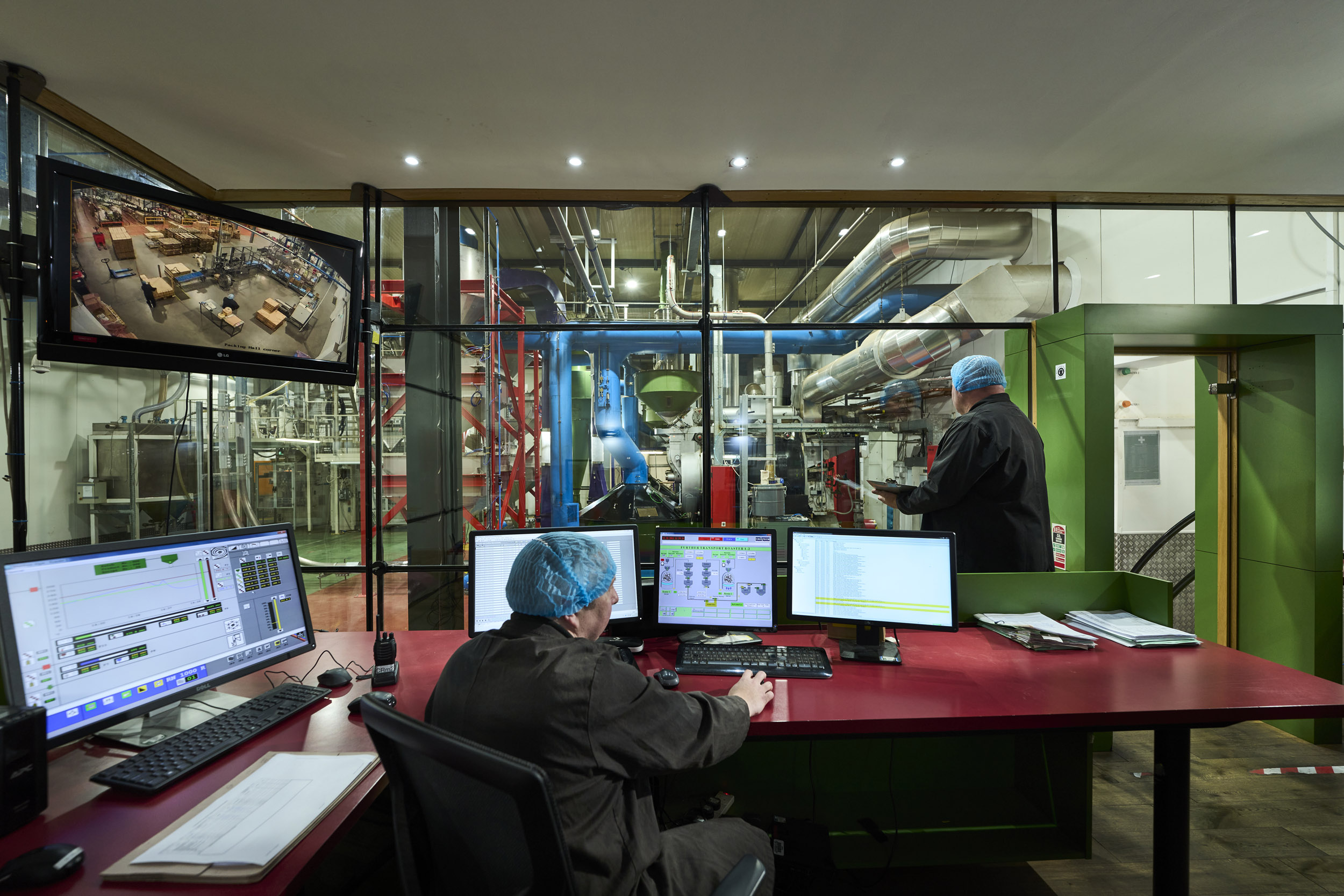 Matthew Algie roastery control room with two employees doing their checks