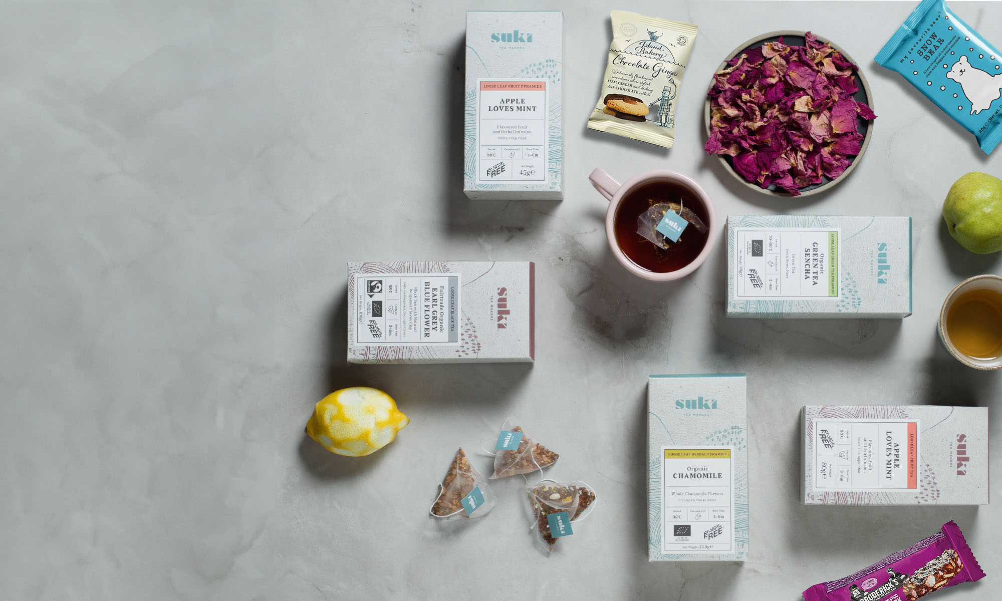 Flat lay of espresso warehouse products including Suki tea, Island bakery biscuits, snow bear biscuits and Brodericks
